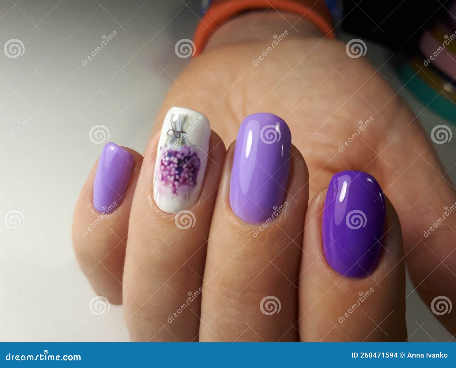 womanÃ¢â¬â¢s hand with laveder violet manicure with white and lavender fingernails